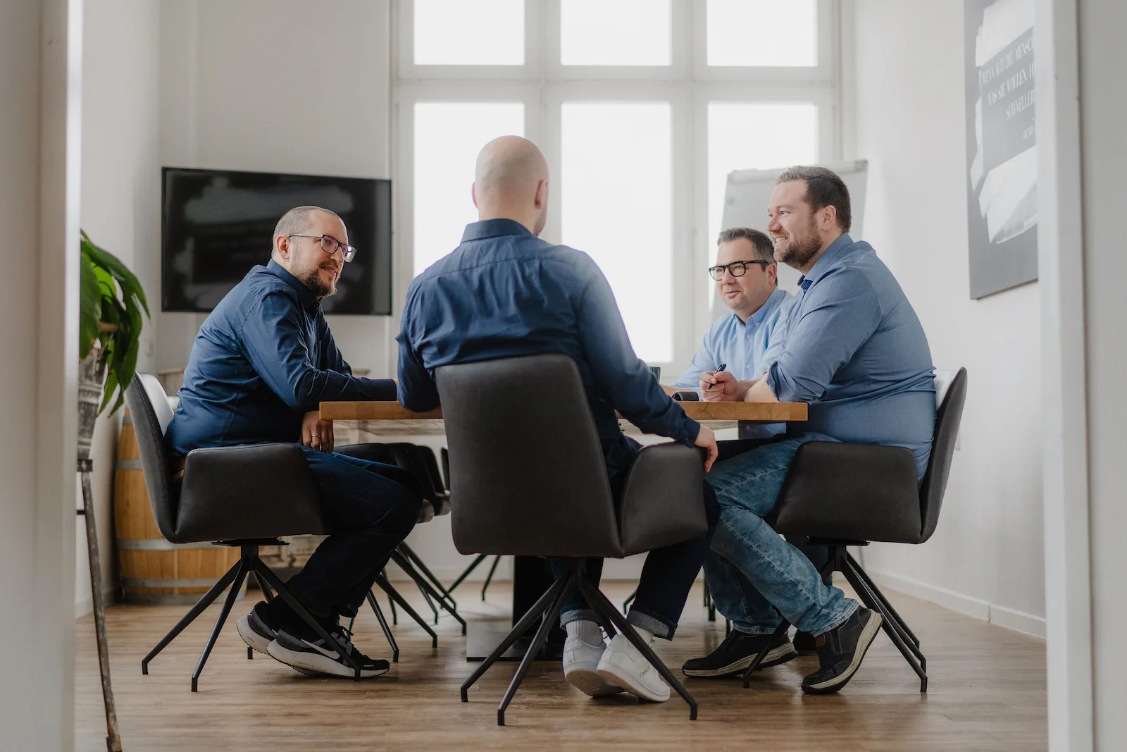 Das Team von Mission Vermoegensaufbau sitzt gemeinsam in einer Beratung.